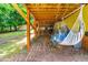 Relaxing hammock with a drink table situated under a wooden deck creating a cozy outdoor nook at 8116 Owenston Ct, Raleigh, NC 27612
