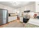 Bright kitchen featuring stainless steel refrigerator and range with granite countertops at 8116 Owenston Ct, Raleigh, NC 27612