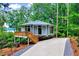Unique exterior of a lake house featuring a deck and staircase leading to a paved driveway and surrounded by trees at 819 & 818 Hilltop Cir, Sanford, NC 27332