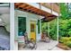 A ground-level porch has rocking chairs on the concrete surface and a yellow door with a window at 819 & 818 Hilltop Cir, Sanford, NC 27332