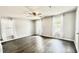 A bright bedroom with hardwood floors, a ceiling fan, and large windows offering ample sunlight at 923 Springfork Dr, Cary, NC 27513