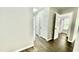 Hallway with wood floors, multiple doors, and view into a bathroom at 923 Springfork Dr, Cary, NC 27513