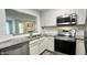 Stylish kitchen featuring stainless steel appliances, granite countertops, and white cabinets at 923 Springfork Dr, Cary, NC 27513