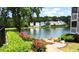 Scenic lake view with beautiful landscaping and several houses in the background at 923 Springfork Dr, Cary, NC 27513