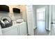 Laundry room with a washer and dryer, storage shelves, and a decorative laundry sign at 923 Springfork Dr, Cary, NC 27513