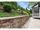 Landscaped backyard featuring a stone retaining wall and manicured garden, creating an inviting outdoor space at 9713 San Remo Pl, Wake Forest, NC 27587