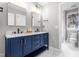 Bright bathroom featuring a double vanity with marble countertop and navy blue cabinets at 9713 San Remo Pl, Wake Forest, NC 27587