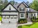 Beautiful two-story home featuring stone accents, a three-car garage, and professionally landscaped front yard at 9713 San Remo Pl, Wake Forest, NC 27587