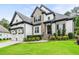 Beautiful home featuring a stone and painted brick facade, well manicured landscaping, and a three-car garage at 9713 San Remo Pl, Wake Forest, NC 27587