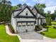 Charming home with landscaped lawn, two-car garage, and stone and white painted brick facade at 9713 San Remo Pl, Wake Forest, NC 27587