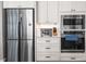 Modern kitchen appliances, including a stainless steel refrigerator, microwave, and oven, complemented by white cabinetry at 9713 San Remo Pl, Wake Forest, NC 27587
