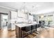 Bright kitchen with stainless appliances, island seating, custom lighting, and views to the breakfast room and backyard at 9713 San Remo Pl, Wake Forest, NC 27587