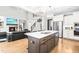 Open-concept kitchen with white cabinets, granite countertops, stainless steel appliances, and a large center island at 9713 San Remo Pl, Wake Forest, NC 27587