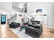 Spacious open-concept living room, with black leather furniture, open staircase, and seamless access to the kitchen at 9713 San Remo Pl, Wake Forest, NC 27587