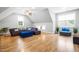 Bright living room boasts hardwood floors, modern lighting, and stylish purple sofa with a blue ottoman at 9713 San Remo Pl, Wake Forest, NC 27587