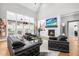 Sunlit living room with fireplace, built-ins, and large windows offering scenic views, adjacent to a black leather sofa at 9713 San Remo Pl, Wake Forest, NC 27587