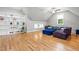 Bright living room boasts hardwood floors, modern lighting, and stylish purple sofa with a blue ottoman at 9713 San Remo Pl, Wake Forest, NC 27587