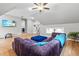 Bright living room boasts hardwood floors, modern lighting, and stylish purple sofa with a blue ottoman at 9713 San Remo Pl, Wake Forest, NC 27587