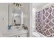 Bright bathroom featuring a large mirror, single sink vanity, and a shower with decorative curtain at 1008 Sandlin Pl # J, Raleigh, NC 27606
