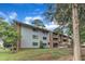 A light blue two-story building with brick accents, a manicured lawn, and mature trees at 1008 Sandlin Pl # J, Raleigh, NC 27606