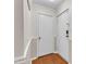 Hallway featuring two white doors with traditional trim and wood floors at 1008 Sandlin Pl # J, Raleigh, NC 27606