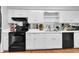 Well-lit kitchen featuring sleek black appliances, white cabinets and white countertops at 1008 Sandlin Pl # J, Raleigh, NC 27606