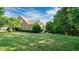 Large, well-maintained backyard with a lush green lawn and mature shade trees at 101 Synandra Ln, Holly Springs, NC 27540