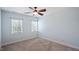 A simple and bright bedroom featuring two windows and a ceiling fan at 101 Synandra Ln, Holly Springs, NC 27540