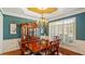 Formal dining room featuring hardwood floors, elegant chandelier, and large windows with plantation shutters at 101 Synandra Ln, Holly Springs, NC 27540