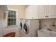 Well-organized laundry room with white cabinets and modern washer and dryer at 101 Synandra Ln, Holly Springs, NC 27540