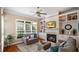 Cozy living room featuring a fireplace, built-in shelves, and large windows at 101 Synandra Ln, Holly Springs, NC 27540