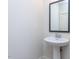 Stylish powder room featuring a pedestal sink, modern faucet, and framed mirror at 1013 Coldspring Circle, Durham, NC 27705