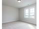 Bright, carpeted bedroom with a double window showcasing neighborhood views at 1013 Coldspring Circle, Durham, NC 27705