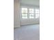 Bedroom features plush carpet, three windows, and white trim at 1013 Coldspring Circle, Durham, NC 27705