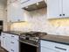Contemporary kitchen featuring white cabinets, stainless steel appliances, and designer backsplash at 1013 Coldspring Circle, Durham, NC 27705