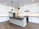 Modern kitchen featuring white cabinets, an island, pendant lights and stainless steel appliances at 1013 Coldspring Circle, Durham, NC 27705