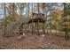 Unique backyard featuring a treehouse with a staircase and a firepit area with seating, perfect for entertaining at 103 Pony Express Cv, Louisburg, NC 27549