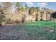 Expansive backyard with lush green grass, mature trees, and a view of the tranquil lake, ideal for outdoor activities at 103 Pony Express Cv, Louisburg, NC 27549