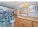 Bathroom with a wooden vanity, framed mirror, and patterned shower curtain at 103 Pony Express Cv, Louisburg, NC 27549