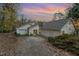 Inviting two-story home with a two-car garage and mature trees against a beautiful sunset at 103 Pony Express Cv, Louisburg, NC 27549