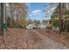 Charming home exterior with mature landscaping, featuring a driveway covered in fallen leaves at 103 Pony Express Cv, Louisburg, NC 27549