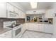 Bright kitchen with white cabinets, granite countertops, and stainless steel appliances overlooking the spacious living area at 103 Pony Express Cv, Louisburg, NC 27549