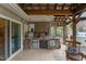 Well-equipped outdoor kitchen with stone countertops, modern appliances, and a cozy seating area for entertaining guests at 103 Pony Express Cv, Louisburg, NC 27549