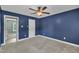 Bedroom with blue walls, carpeted floor, ceiling fan and white doors at 105 Poplar Dr. Dr, Clayton, NC 27520