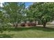 Well-manicured lawn with lush greenery framing a cozy home featuring mature shade trees at 105 Poplar Dr. Dr, Clayton, NC 27520