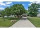 Long driveway leading to a well-kept home with a covered carport and lush green surroundings at 105 Poplar Dr. Dr, Clayton, NC 27520