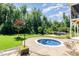 Inviting backyard with a cozy plunge pool, lounge area with pergola, and lush green landscaping at 1131 Lowland St, Apex, NC 27523