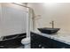 Updated bathroom features unique black squared vessel sink, granite countertop, and black-trimmed tub with hexagonal tiles at 1131 Lowland St, Apex, NC 27523