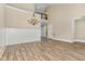 Open-concept dining room with wood-look floors and a chandelier, adjacent to the foyer at 1131 Lowland St, Apex, NC 27523