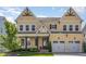 Traditional two-story yellow house with a covered front porch, trimmed shrubbery, and two-car garage at 1131 Lowland St, Apex, NC 27523